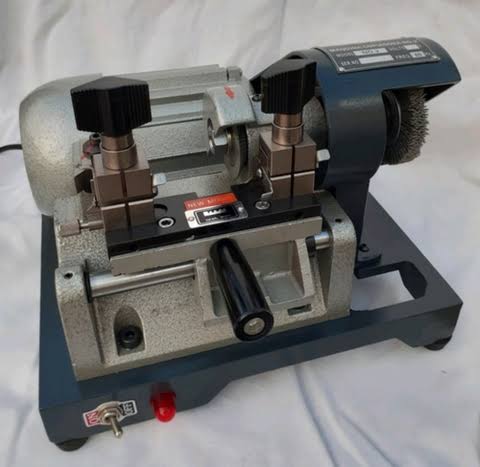 Locksmith in workshop makes new key, use grinding engraving machine